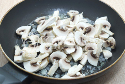 Добавить нарезанные ломтиками грибы шампиньоны, готовить 3-4 минуты.
