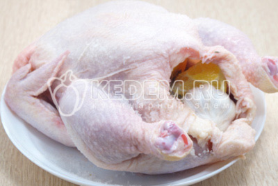 Нарезанные апельсины, нарезанную головку чеснока и несколько сухих веточек тмина, вложить внутрь курицы. Хорошо утрамбовать.