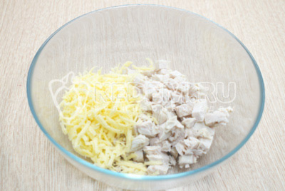 В миску мелко нарезать отварное куриное филе и 100 грамм сыра натереть на терке.