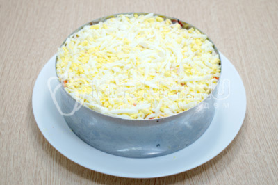 Выложить верхним слоем тертые отварные яйца и смазать 1-2 ложками майонеза.
