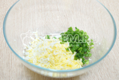 В миске смешать тертые отварные яйца и мелко нашинкованный зеленый лук.