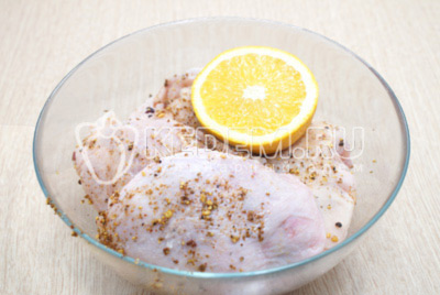 Переложить куриные бедра в глубокую миску и с половины апельсина выдавить сок. Оставить на 30 минут.