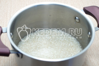 Высыпать рис в кастрюлю и залить ½ литра воды.