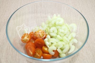 В миску нарезать помидоры черри половинками, ломтиками нарезать сельдерей.