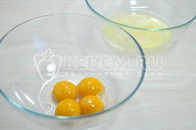 Разбить 4 яйца в две миски, желтки и белки отдельно.