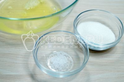 В миску с белками добавить 2 столовые ложки сахара и 1 щепотку соли.