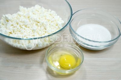 В миску выложить 400 грамм творога, добавить 1 яйцо и 100 грамм сахара.