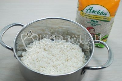 Переложить рис в кастрюлю, залить 400 миллилитров воды и поставить варить без крышки, посолить по вкусу.