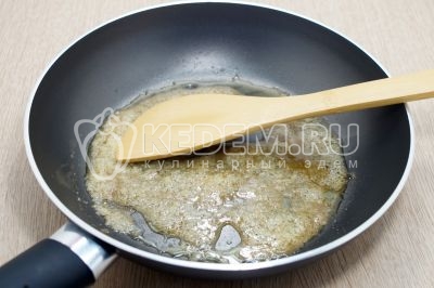 Добавить 2 столовые ложки сахара и растопить его, постоянно помешивая лопаткой до образования карамели.