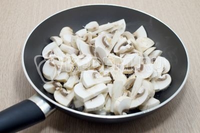 300 грамм грибов шампиньонов нарезать ломтиками. Обжарить грибы шампиньоны на сковороде с маслом.