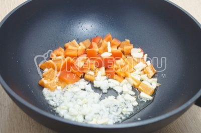Обжарить в разогретом подсолнечном масле, мелко нашинкованную луковицу, нарезанный чеснок и кубиками нарезанный болгарский перец.