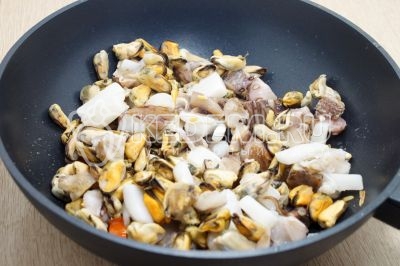 Добавить морепродукты и готовить 3-4 минуты, помешивая. Посолить и поперчить по вкусу.