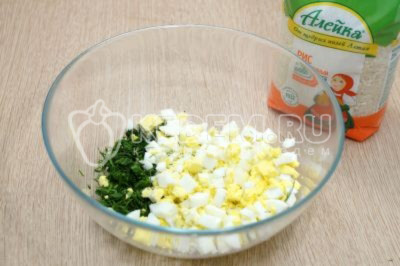 В миску нарезать кубками отварные яйца, добавить мелко нашинкованную зелень укропа и петрушки.