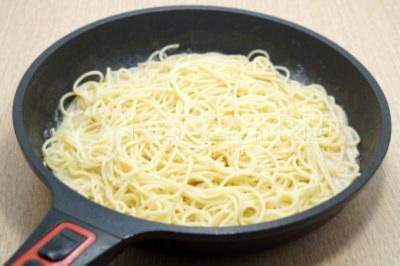 Добавить горячие спагетти в сковороду и перемешать, готовить еще 2-3 минуты.