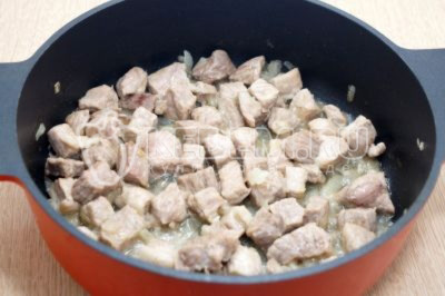 Добавить кубиками нарезанное мясо и обжарить помешивая 5-6 минут на среднем огне, так чтобы лук не подгорел.