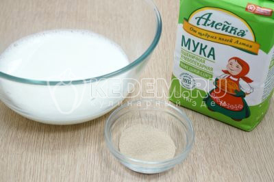 В миску влить теплое молоко, добавить 1 чайную ложку сухих дрожжей.