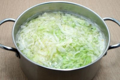 Добавить нашинкованную капусту в кастрюлю к картофелю. Варить 2-3 минуты. 