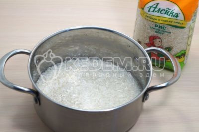 Промытый рис переложить в кастрюлю, влить 500 миллилитров воды и варить помешивая 10-13 минут.