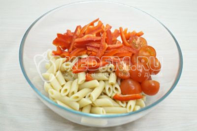 В миску с макаронами нарезать помидоры черри половинками и соломкой болгарский перец.