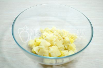 Отварной картофель нарезать кубками в миску.