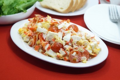 Салат с крабовыми палочками, помидорами, яйцами и сыром готов