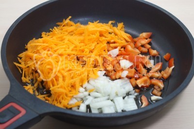 На сковороде обжарить мелко нашинкованный лук, тертую морковь и кубика им нарезанный болгарский перец. Готовить помешивая 2-3 минуты.