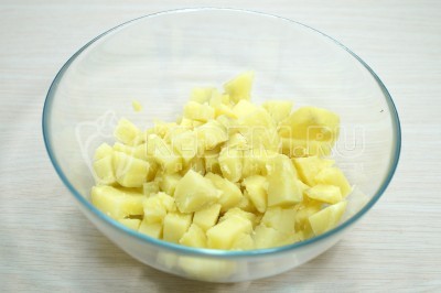 Нарезать картофель кубиком в миску.