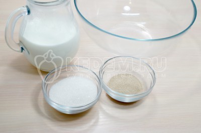 В большую миску влить 300 миллилитров теплого молока, добавить 4 столовые ложки сахара и 10 грамм сухих дрожжей. Перемешать.