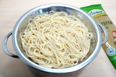 Откинуть спагетти на дуршлаг и дать воде стечь.