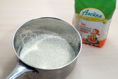 Высыпать рис в сотейник, влить 300 миллилитров воды.