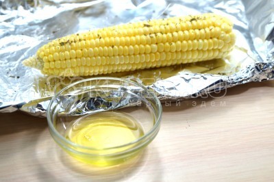 Смазать растительным маслом, примерно по 1 чайной ложке на каждый початок кукурузы.