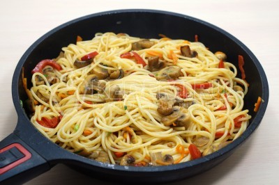 Добавить спагетти в сковороду и перемешать.