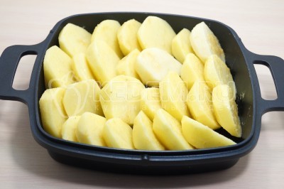 Выложить кусочки картофеля в форму для запекания.