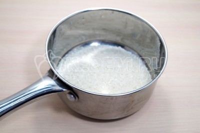 100 грамм риса отмерить и высыпать в сотейник, добавить 300 миллилитров воды и варить 12-15 минут, до готовности. Рис откинуть на сито и остудить.