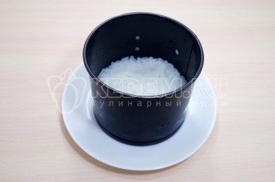 На блюдо установить сервировочное кольцо. Выложить отварной рис, посолить по вкусу.