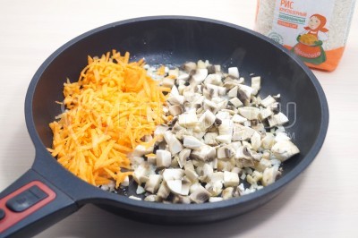 Добавить тертую морковь и мелко нарезанные грибы. Готовить помешивая 3-4 минуты.