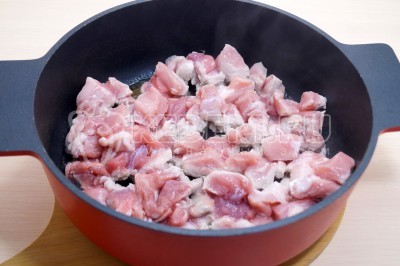 Добавить кусочками нарезанное мясо и обжарить 5-6 минут, помешивая, до румяной корочки.