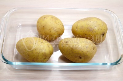 Чтобы приготовить салат салат по-немецкий с картофелем, нужно 4 картофелины вымыть, обсушить и выложить в форму для запекания.