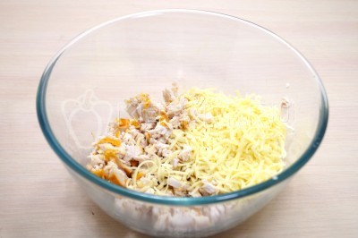 В миске перемешать нарезанную копченую курицу и тертый сыр.