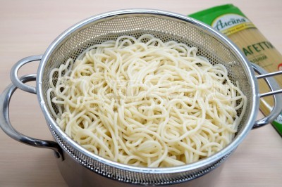 Откинуть отварные спагетти на дуршлаг и дать воде полностью стечь.