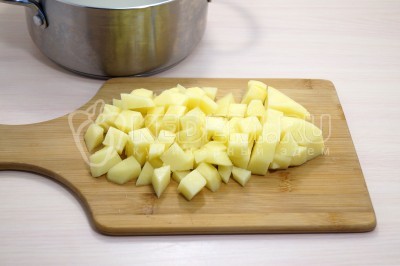 В кастрюлю с рисом добавить кубиками нарезанный картофель.