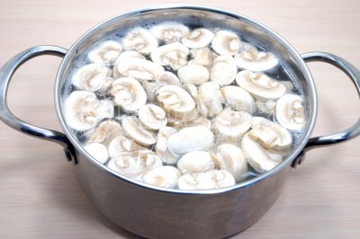 Добавить нарезанные грибы шампиньоны и варить 10-12 минут.