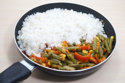 Добавить отварной рис к овощам.