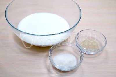 В миску влить 200 миллилитров теплого молока, добавить 10 грамм сухих дрожжей и 1 столовую ложку сахара.