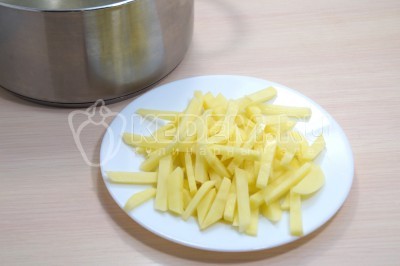 Добавить в бульон 3 нарезанные соломкой картофелины. Варить 2-3 минуты.