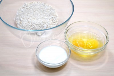 Измельченные хлопья переложить в миску, добавить 60 миллилитров молока и 2 куриных яйца.