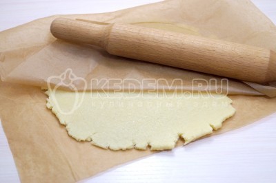 Раскатать тесто в тонкий пласт между двумя листами пергамента при помощи скалки.