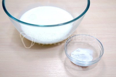 В миску влить 250 грамм теплого кефира. Добавить 1/2 чайной ложки соды и перемешать.