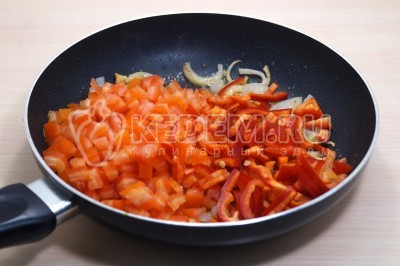 Добавить кубиками нарезанные помидоры и соломкой нарезанный болгарский перец. Готовить, помешивая, 2-3 минуты.