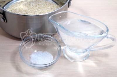 Пересыпать ячневую крупу в кастрюлю и добавить 400 миллилитров воды и 1/2 чайной ложки соли.